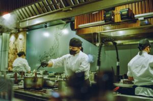 Chefs working in a commercial kitchen, illustrating the dynamic food scene as they prepare meals in Singapore.
