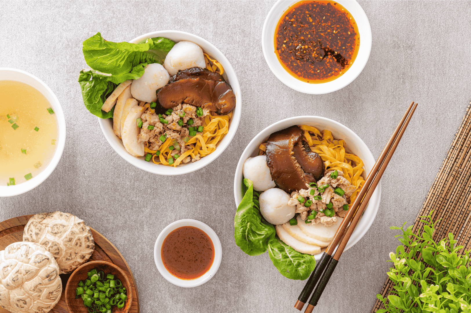 Top-down view of a hearty Asian noodle spread with fish balls, mushrooms, and dipping sauces—showcasing the comforting late-night flavors found in Singapore Chinatown’s after-dark dining scene.