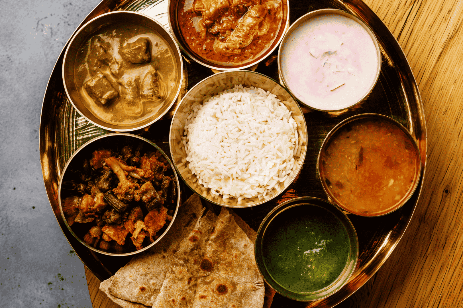 Traditional Indian thali with rice, chapati, and an array of vibrant curries and sides, capturing the rich, spice-laden diversity of Little India’s culinary offerings.