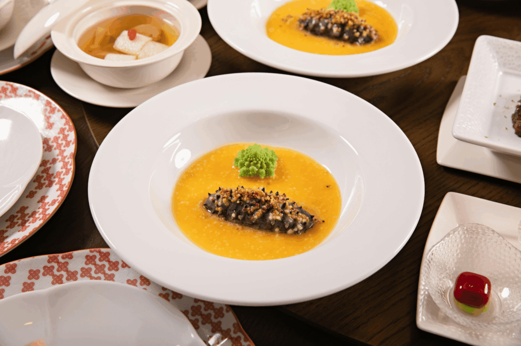 Elegant Michelin-starred tasting menu featuring artfully plated gourmet dishes, vibrant sauces, and refined textures at a Singapore fine dining restaurant.