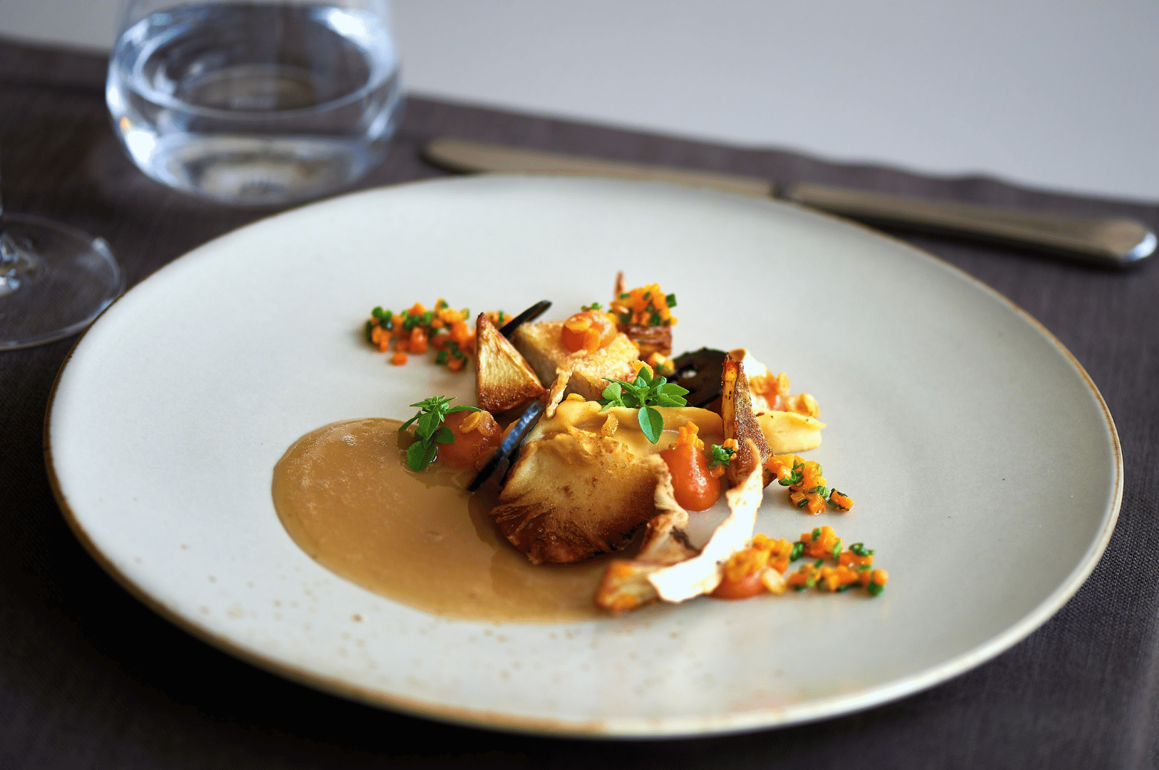 Artfully plated vegan entrée at a Singapore fine dining restaurant, showcasing roasted vegetables, herb garnishes, and vibrant sauces in a modern plant-based presentation.