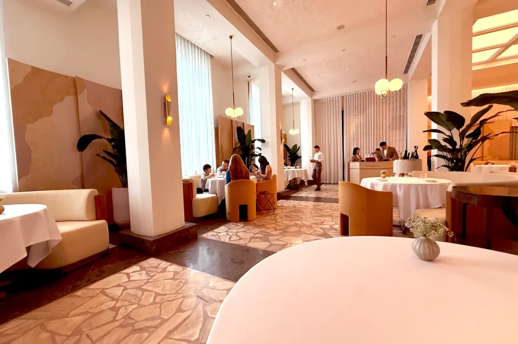 An elegant dining room interior demonstrating how a chef's table changes the way you dine by blending open kitchen views with sophisticated guest seating in Singapore.