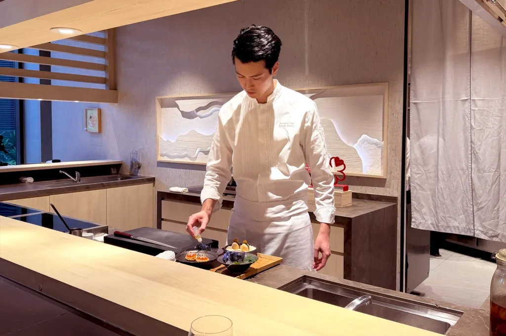 Chef Kazuki Arimoto carefully plating delicate dishes at the counter during an Omakase at Stevens dining experience in Singapore.