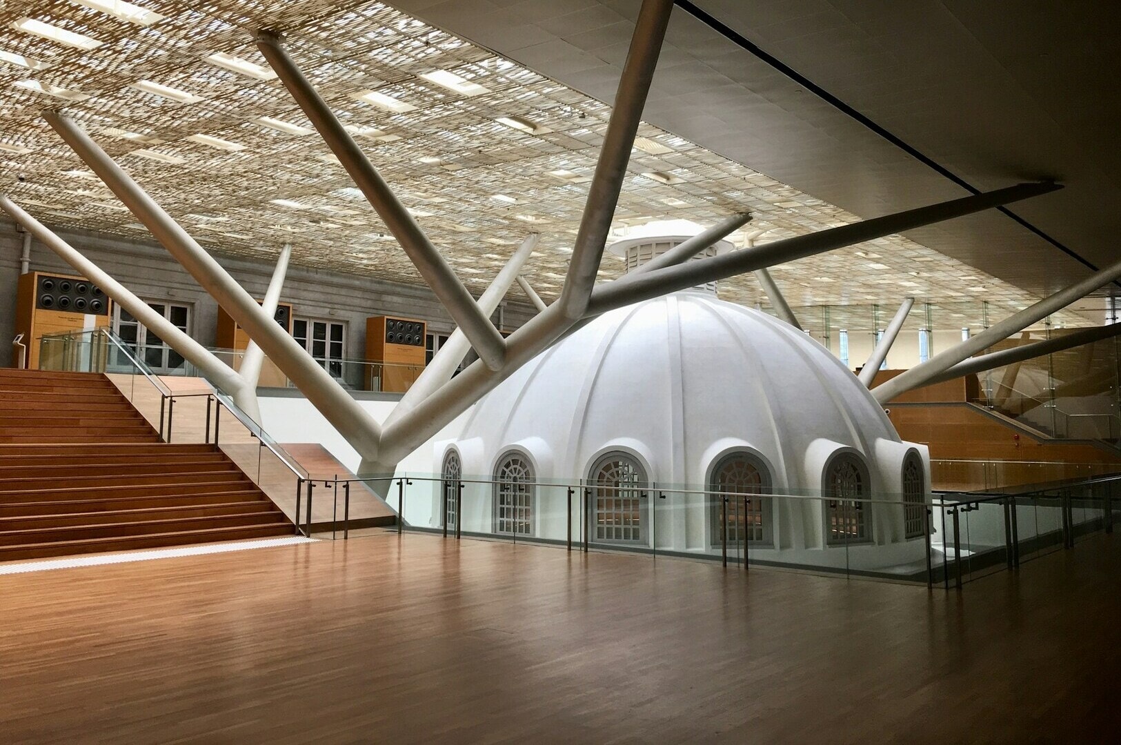 A large white dome with numerous pillars inside, located at the National Gallery Singapore.