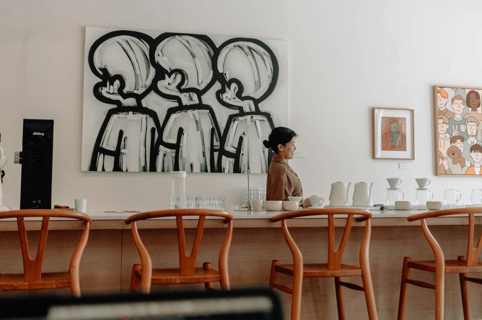 A woman stands at the counter of Singapore Cafe, preparing to serve coffee.