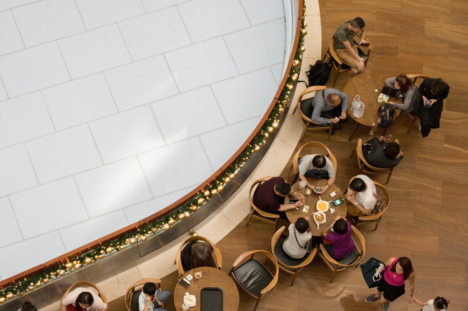 People seated at tables in a restaurant with a view of the Marina Bay from a rooftop setting.