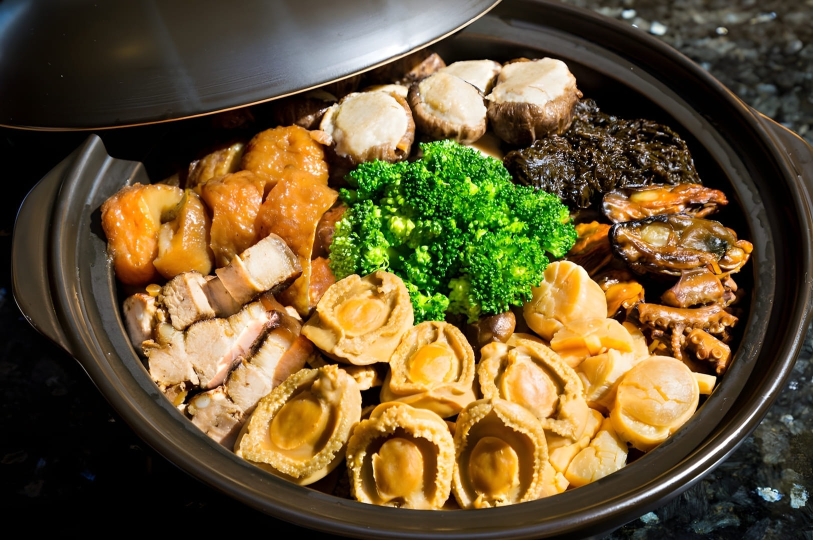 A bowl of Pen Cai, a traditional Chinese New Year dish, filled with various ingredients, sits on a kitchen counter.