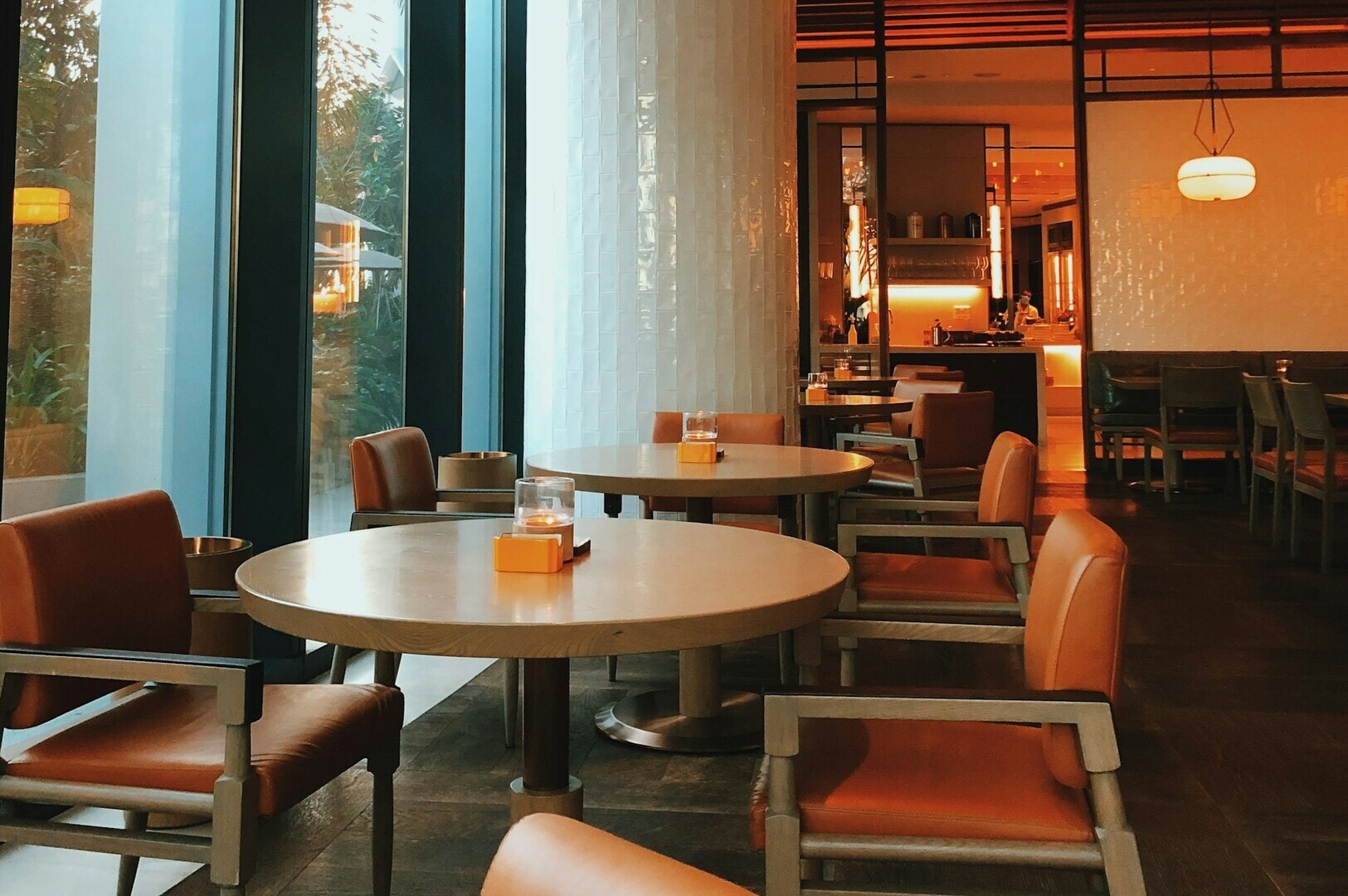 A restaurant in Singapore featuring tables and chairs arranged near large windows, offering a bright and inviting atmosphere.