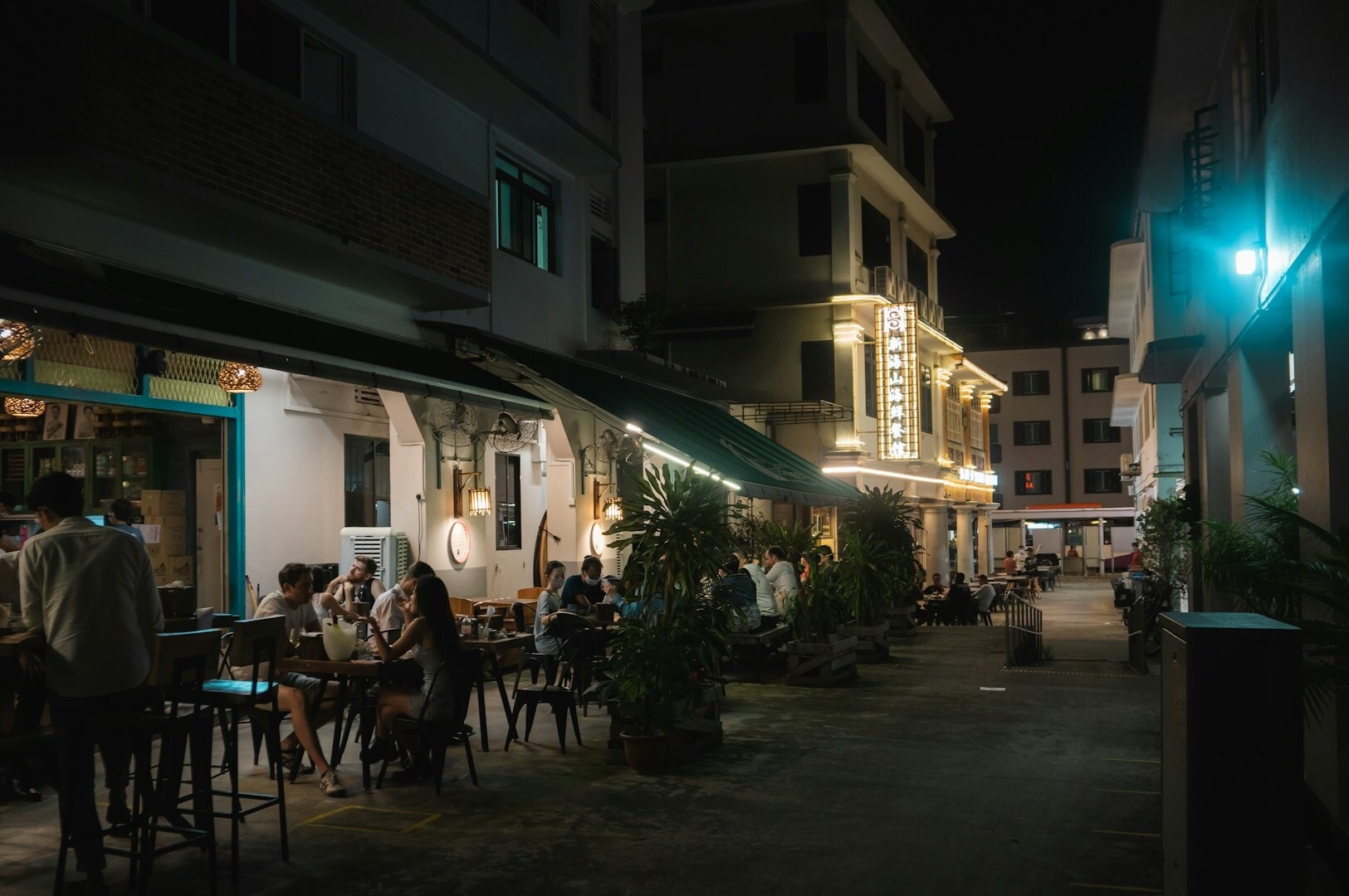 Diners enjoying a cozy night at a restaurant, surrounded by tables and warm lighting, highlighting local favorites.