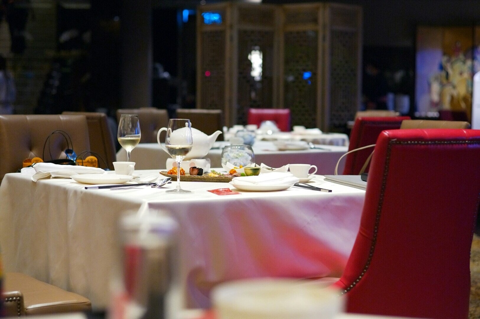 A neatly set table with a white cloth, located in a Singapore restaurant.