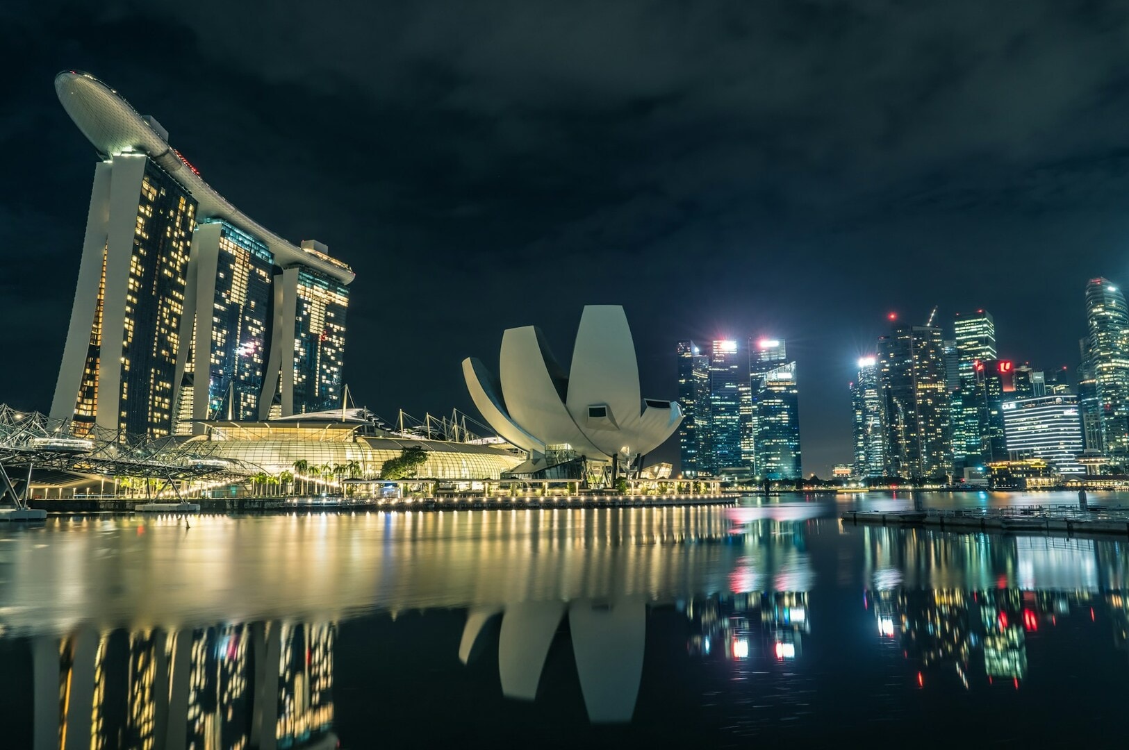 Night view of Singapore's skyline, showcasing illuminated skyscrapers and the vibrant cityscape against a dark sky.