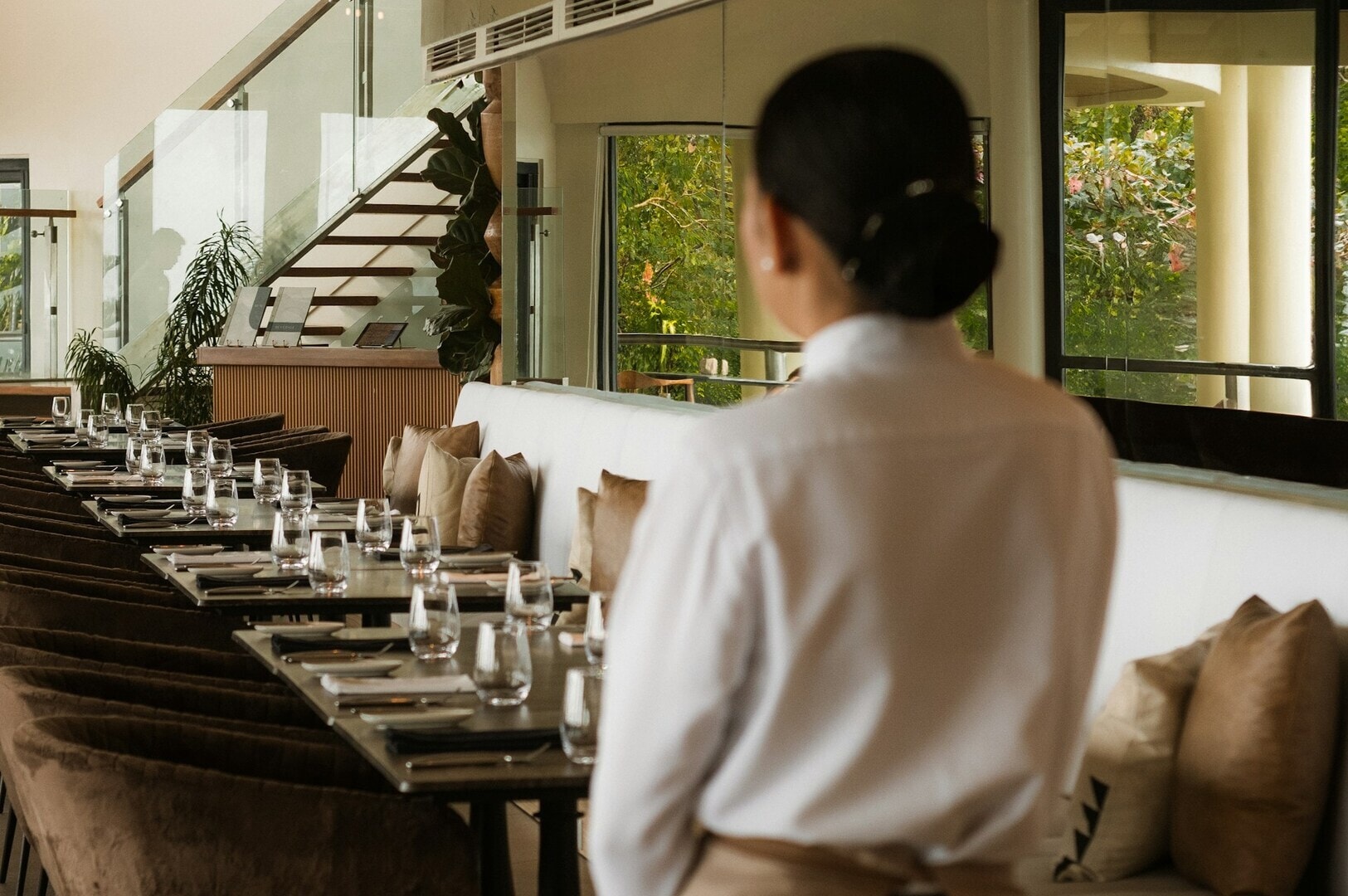 A waitress stands in front of a restaurant table in Singapore, showcasing the dining setup and ambiance.