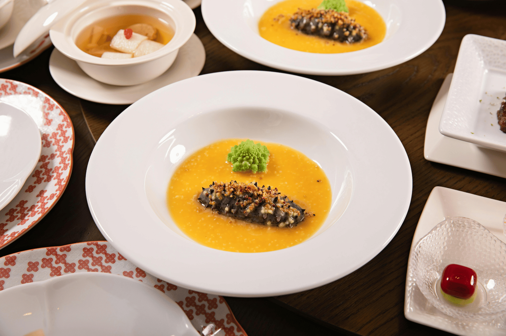 Elegant Michelin-starred tasting menu featuring artfully plated gourmet dishes, vibrant sauces, and refined textures at a Singapore fine dining restaurant.