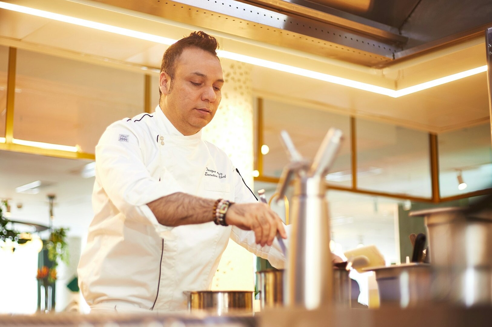 A renowned chef in a Singapore kitchen, focused on preparing exquisite dishes with precision and flair.