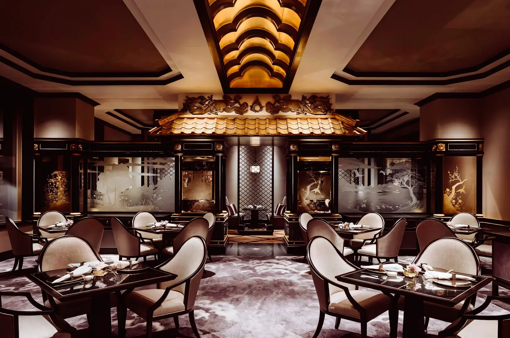 Luxurious Chinese fine‑dining restaurant interior featuring ornate ceiling lighting, gold‑accented decor, and neatly arranged dining tables.