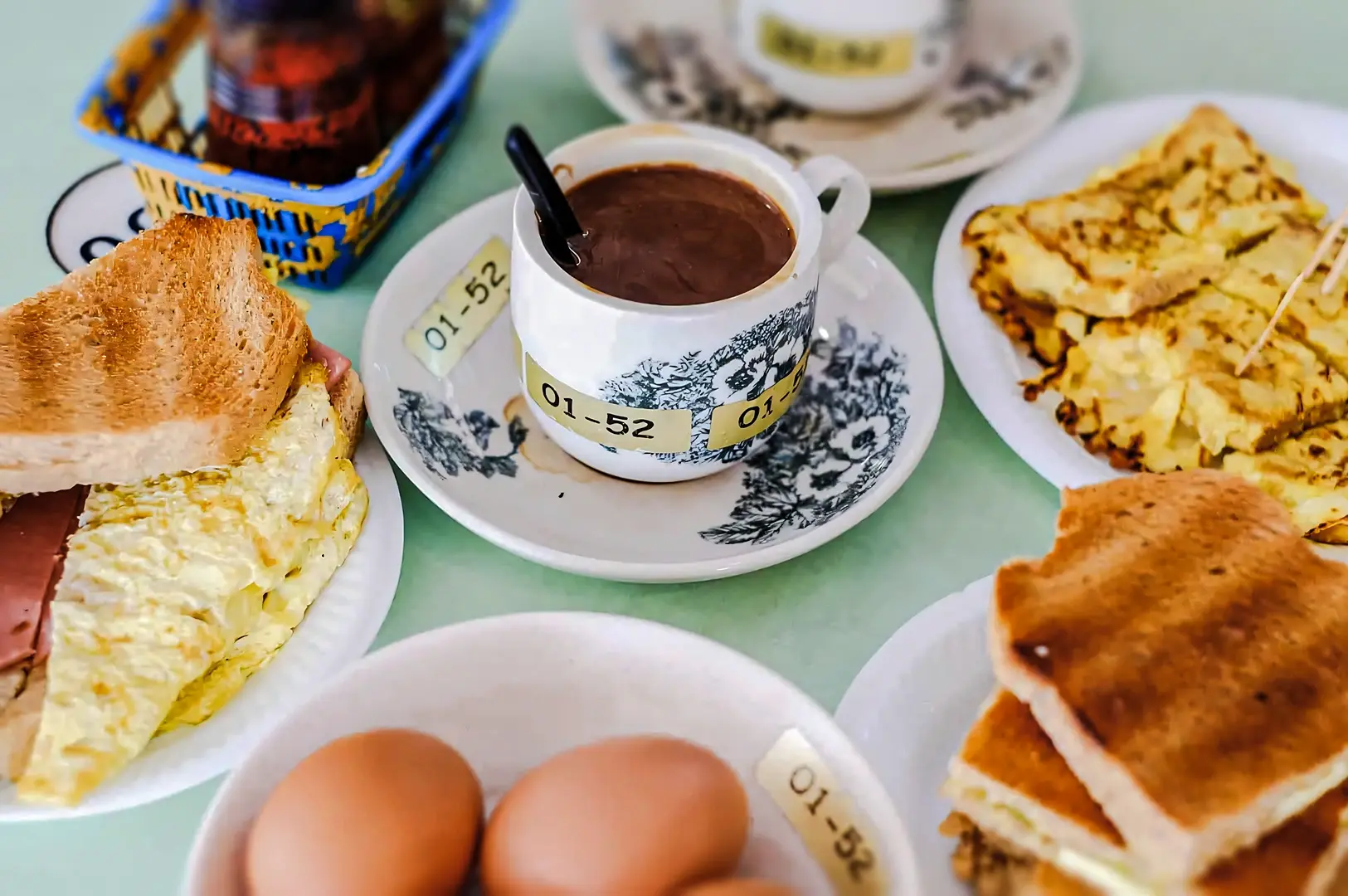 Traditional Singapore kaya toast breakfast set with soft‑boiled eggs, toasted bread, and a cup of local kopi coffee.