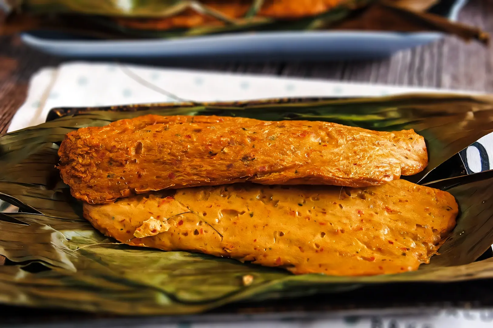 Spicy otah otah grilled fish paste wrapped in banana leaves, a traditional Southeast Asian street food commonly found in Singapore.