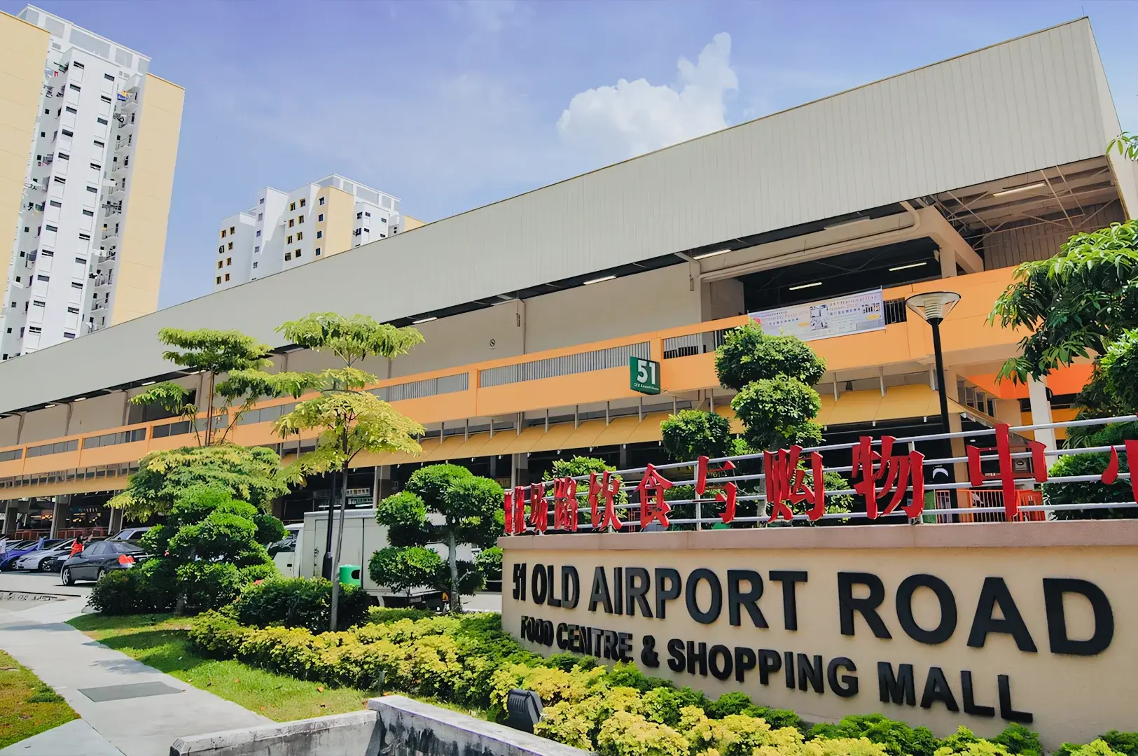 Old Airport Road Food Centre in Singapore, a popular hawker center and shopping mall with greenery and high‑rise buildings in the background.