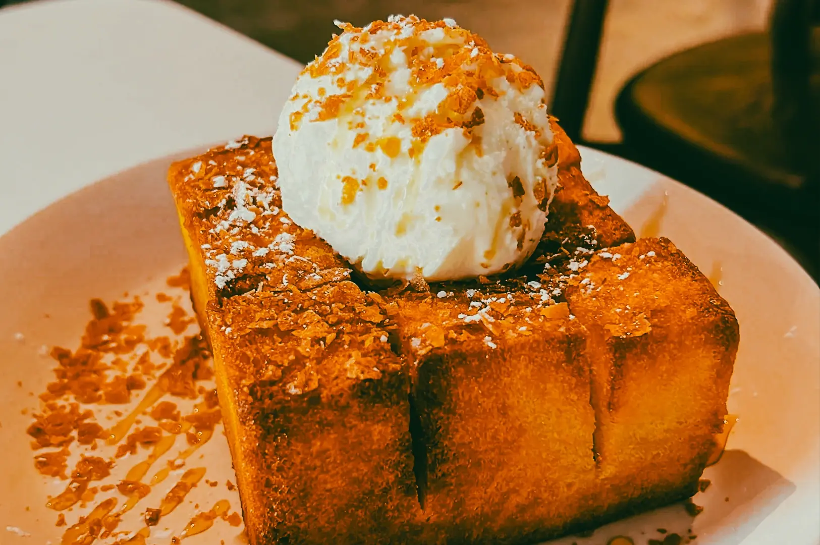 Close-up macro shot of brioche toast topped with vanilla ice cream and caramel drizzle, a popular brunch dessert paired with specialty coffee in Singapore cafes