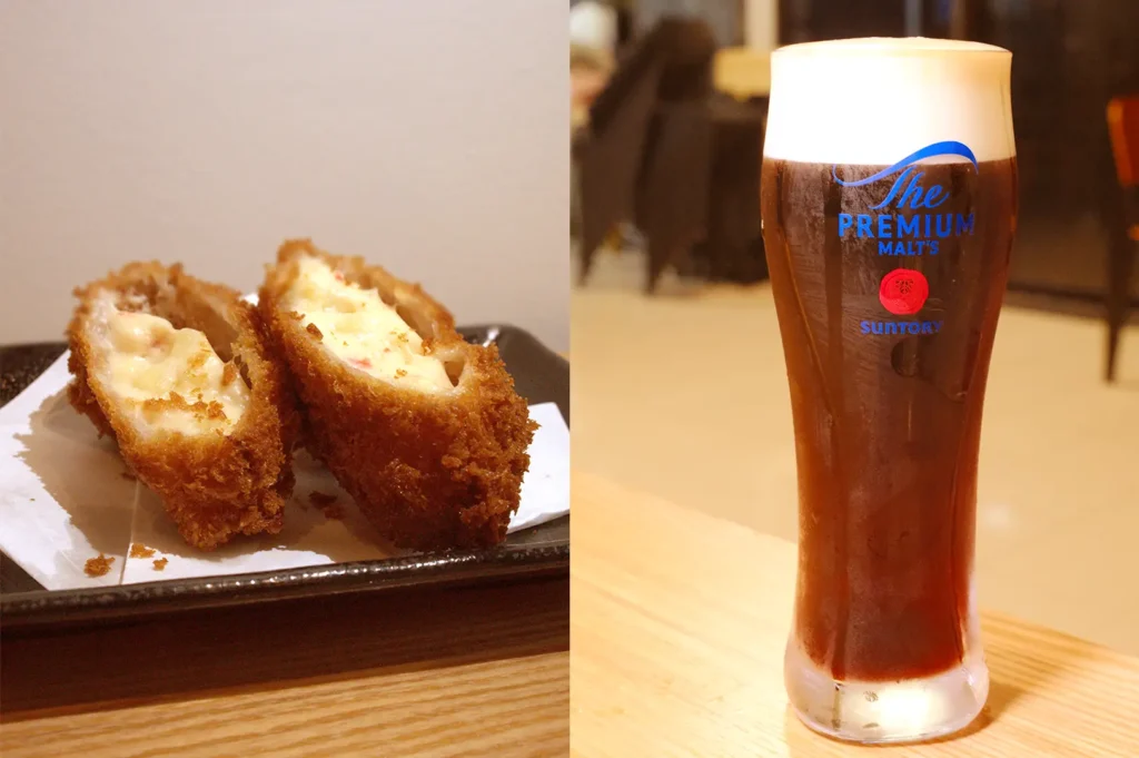 Split view of two crispy golden kani cream croquettes with creamy filling next to a tall glass of cold Suntory The Premium Malt's pilsner beer.