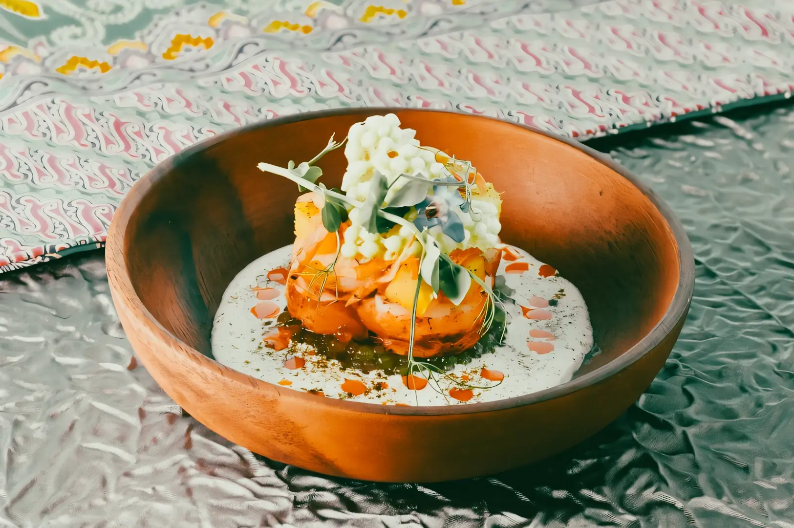 Deconstructed laksa served in a wooden bowl with coconut curry sauce and herbs, representing innovative Singapore cuisine 2026.