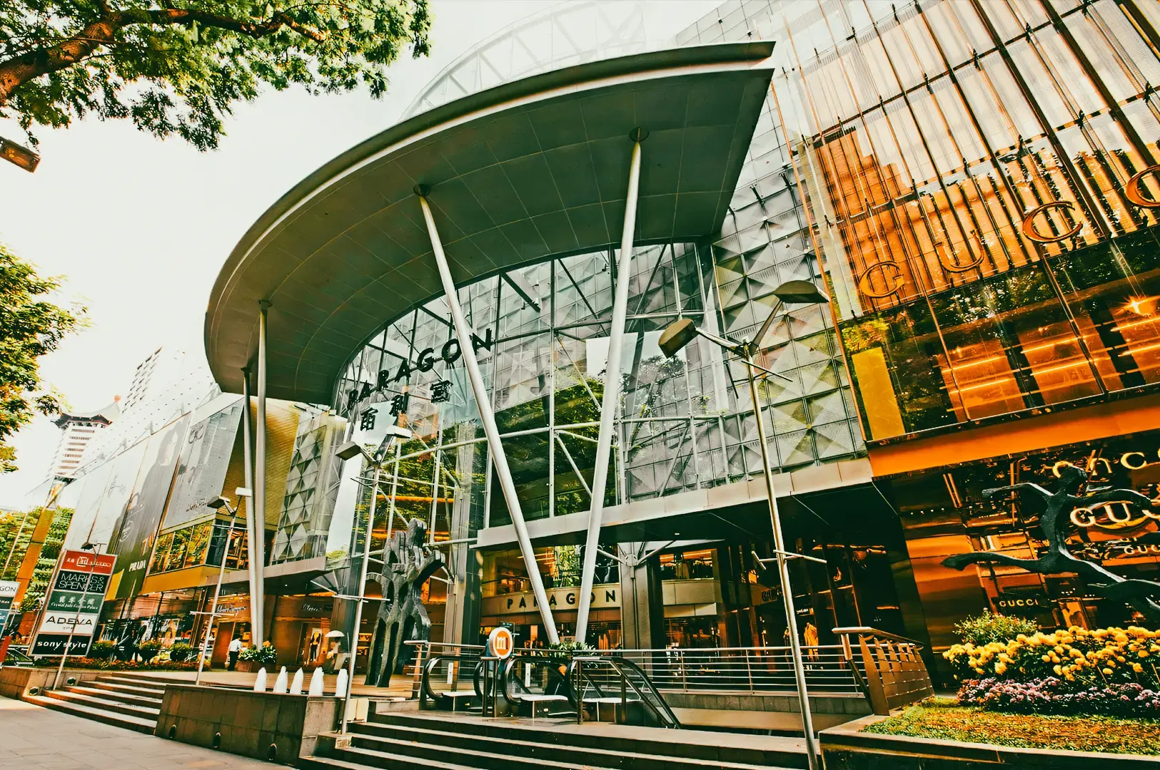 Paragon shopping centre Singapore exterior with luxury retail and dining destinations, representing modern gastronomy and fine dining evolution in Singapore, low-angle wide architectural shot
