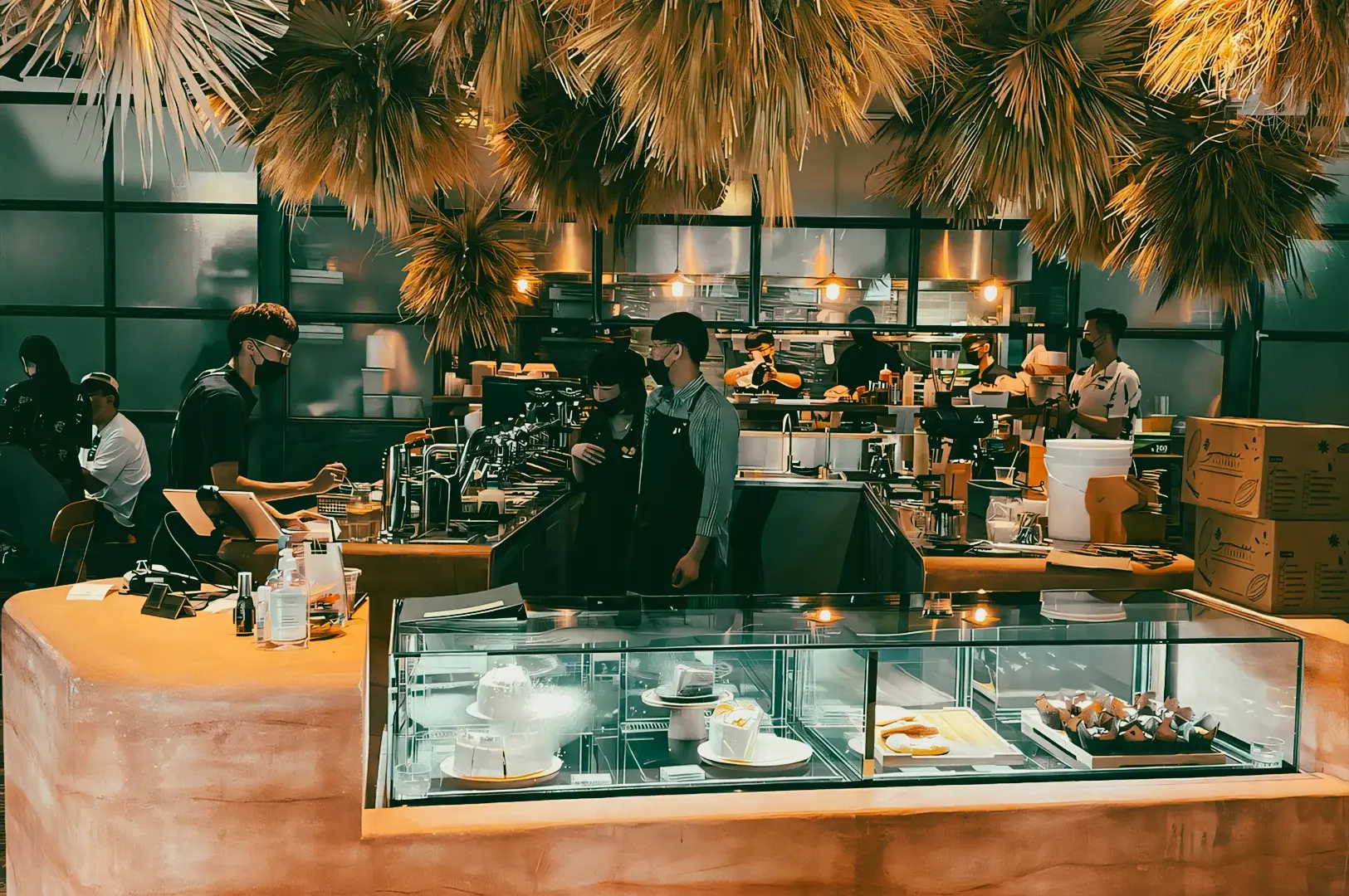 Wide-angle interior shot of a busy Singapore specialty coffee cafe with baristas preparing espresso and pastries, showcasing artisan coffee culture and brunch scene