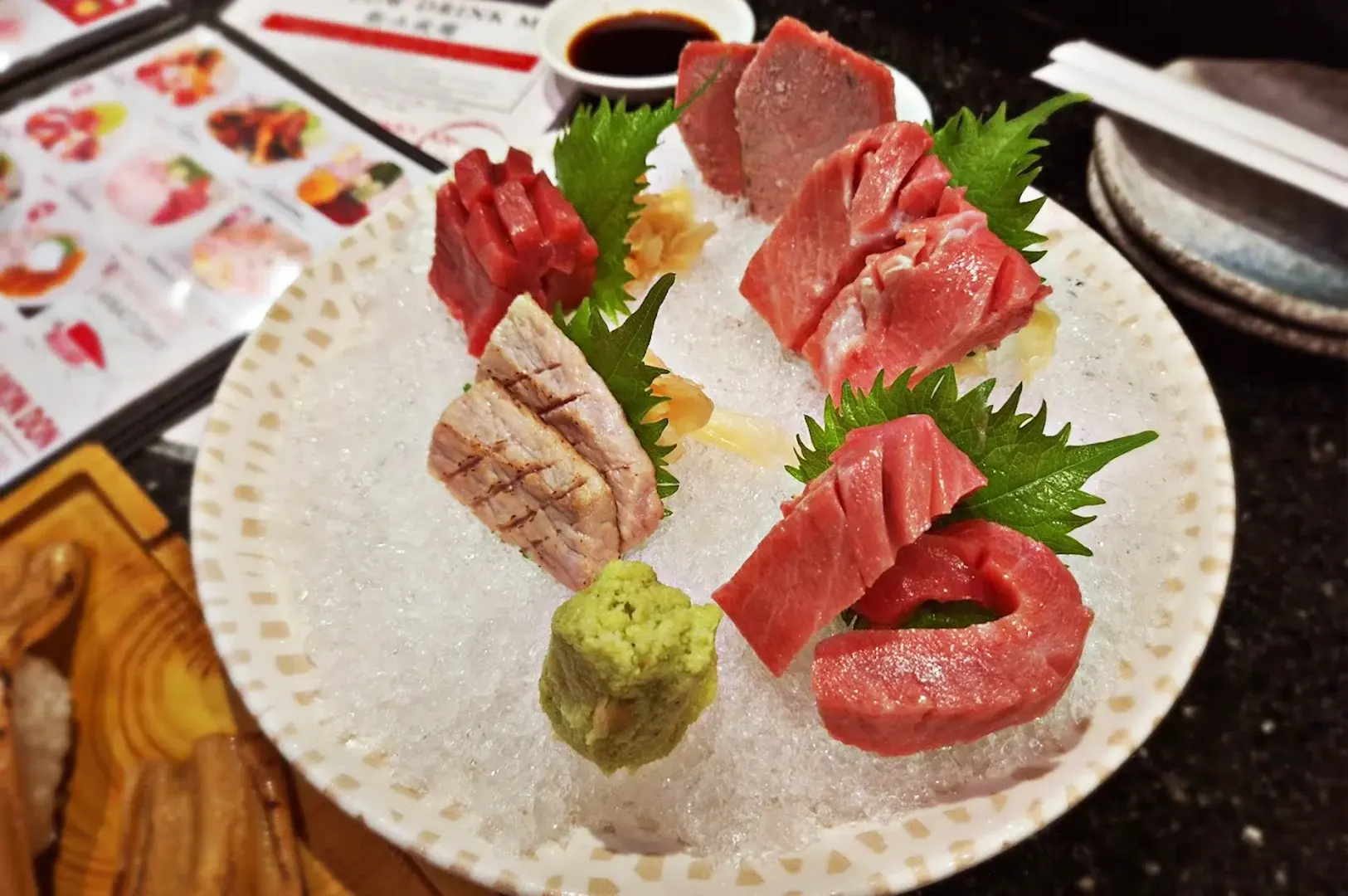 The signature and premium Maguro 5-cut Sashimi platter, served on a bed of ice at Kuro Maguro Sushi and Dining, featuring various cuts of fresh tuna.