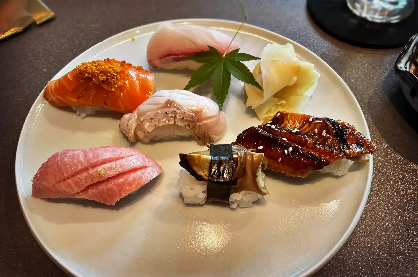A beautifully presented platter of assorted premium nigiri sushi, including tuna and eel, served as part of a lunch omakase set.