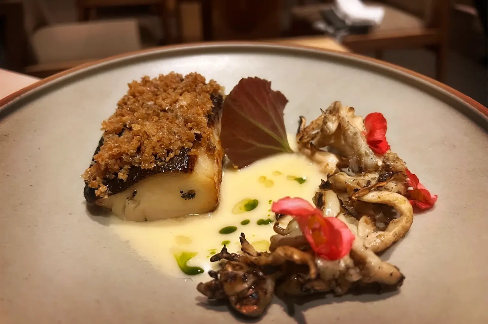 Artfully plated gourmet dish featuring Miso-glazed black cod, served with mushroom garnish and creamy sauce at OUMI, highlighting modern Japanese culinary techniques.