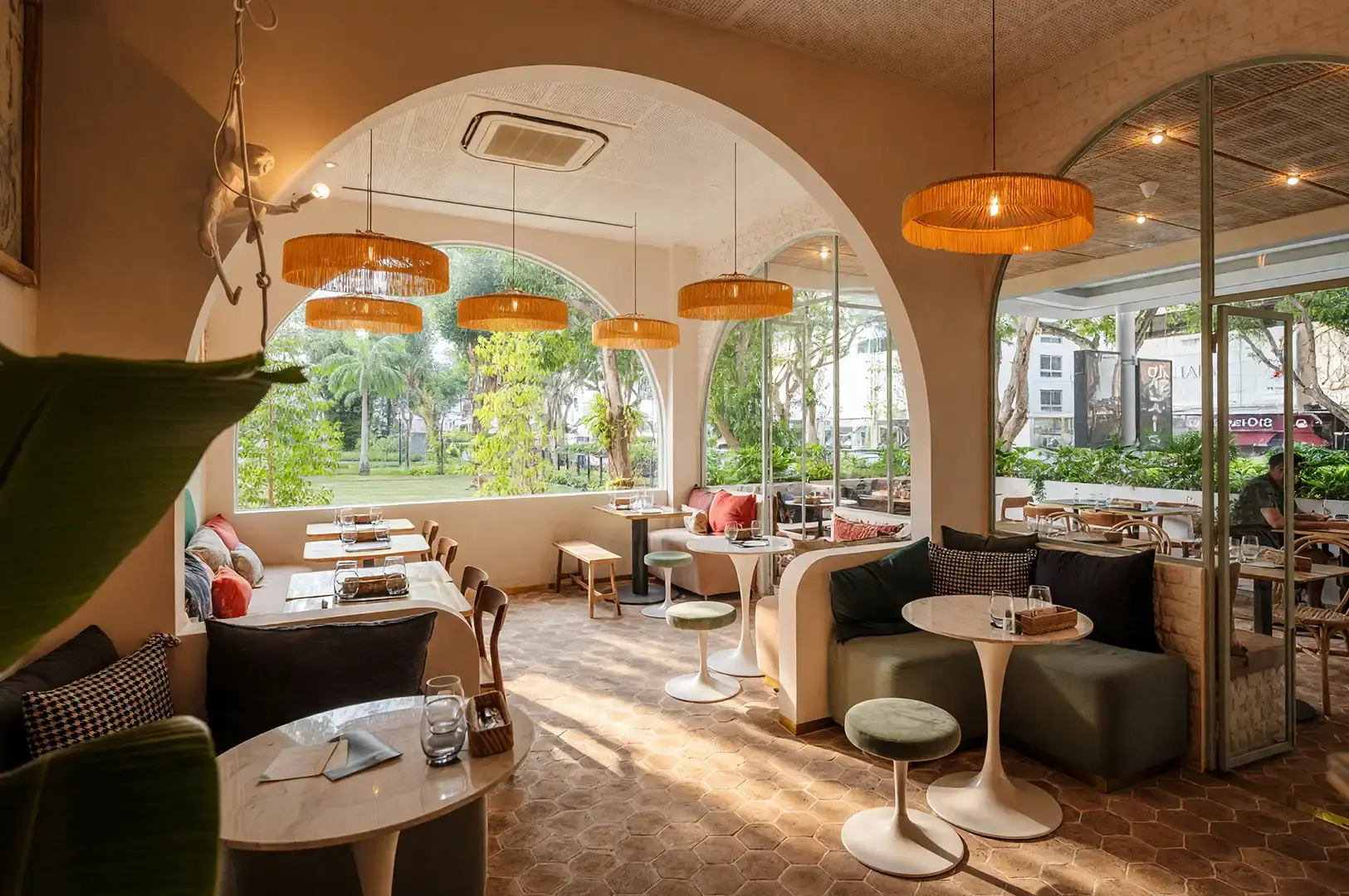 Bright and airy interior of Merci Marcel at Palais Renaissance with elegant arched windows, warm ambient lighting, and comfortable bistro seating for a relaxed French brunch experience.