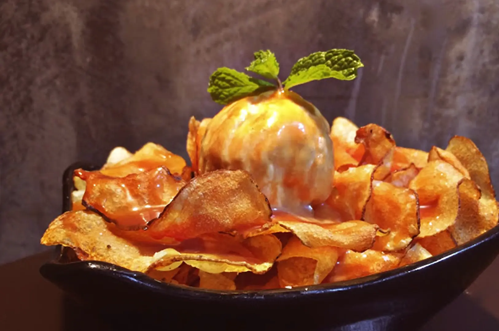 The Chips N Cream dessert, featuring crispy potato chips topped with a scoop of ice cream and a drizzle of caramel at KPO Café Bar.
