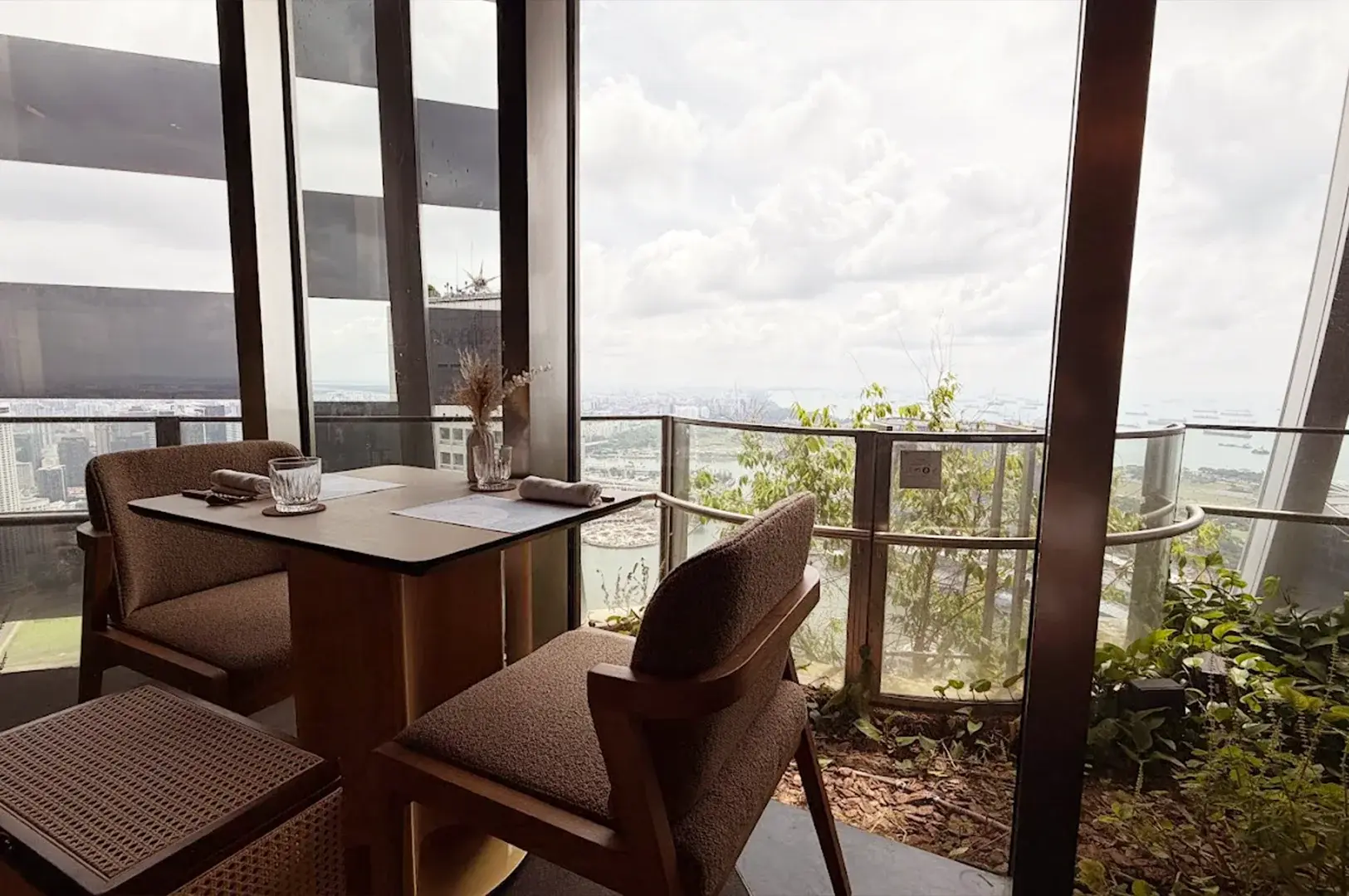 A cozy dining table with a stunning panoramic view of the city and harbor at OUMI, a premier Japanese restaurant in Tanjong Pagar.