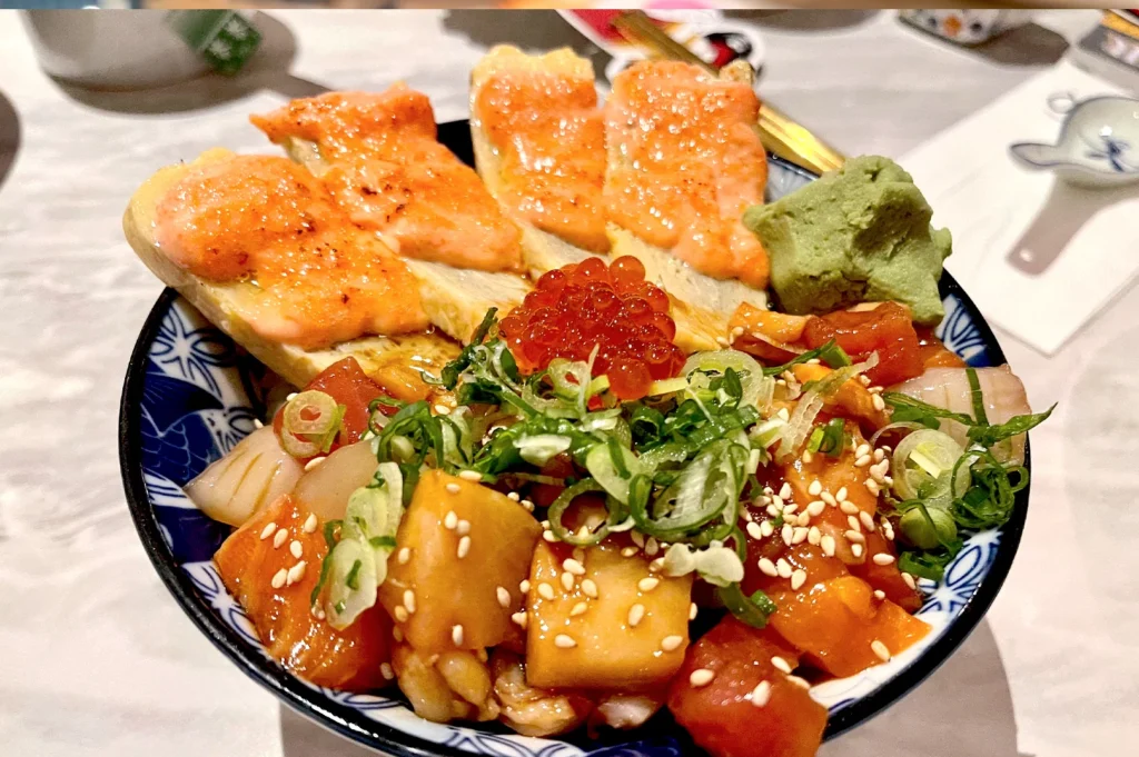 Tamago Mentai Chirashi bowl served at Omote, topped with creamy torched tamago, fresh salmon roe, and a variety of mixed sashimi pieces.