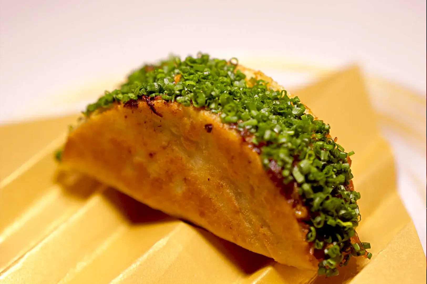A signature dish from Thevar Singapore’s tasting menu, the Chettinad Chicken Roti, featuring a perfectly charred, modern Indian creation topped with fresh chives, showcasing the restaurant's focus on bold, refined flavors.