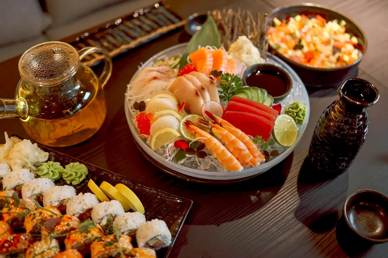 An elegant, fresh sashimi platter served on ice with a teapot and sake carafe, illustrating the premium side of the Singaporean sushi dining experience.