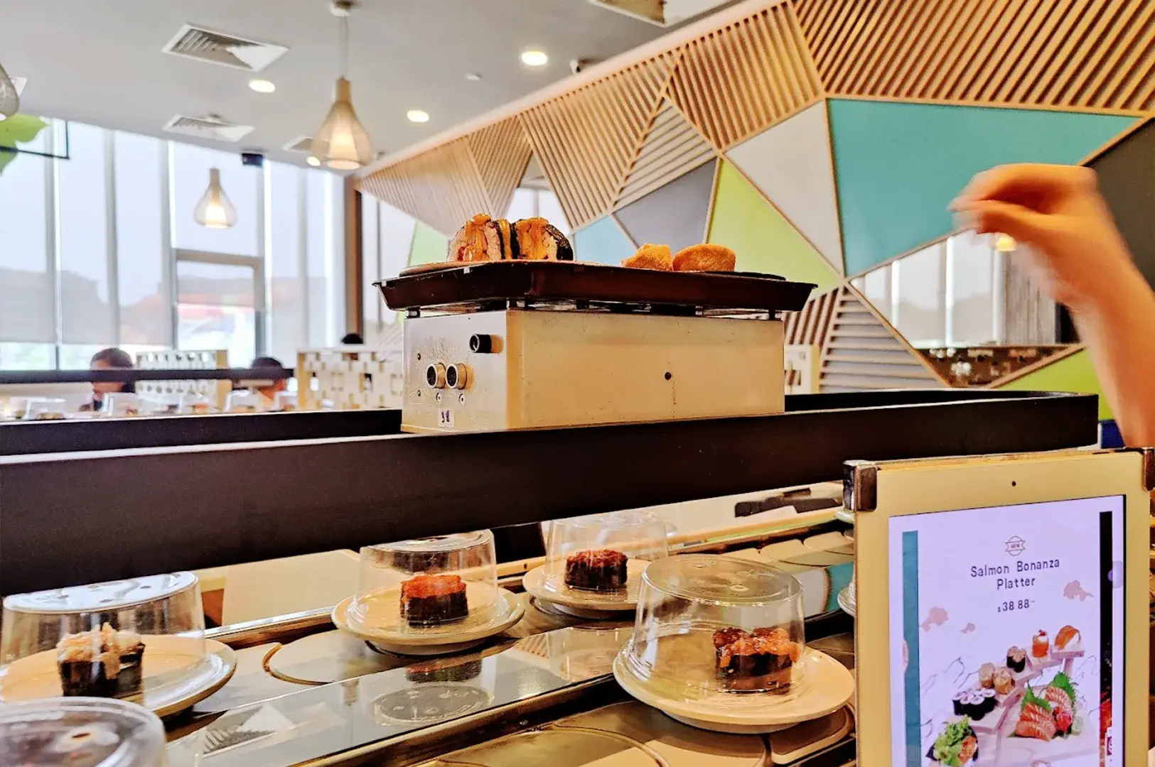 A view of a sushi train conveyor belt system at Hei Sushi in Singapore, demonstrating the efficiency of modern conveyor belt dining.