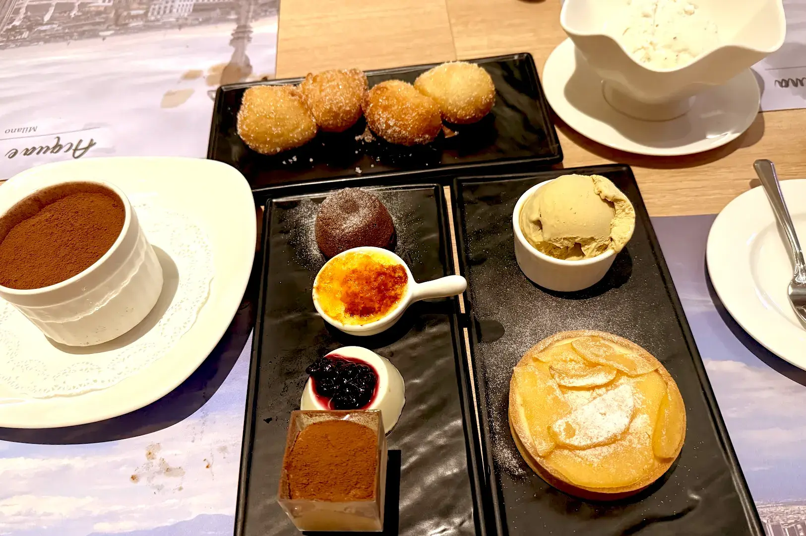 A decadent spread of traditional Italian desserts at Acqua e Farina, featuring tiramisu, gelato, panna cotta, and assorted pastries.