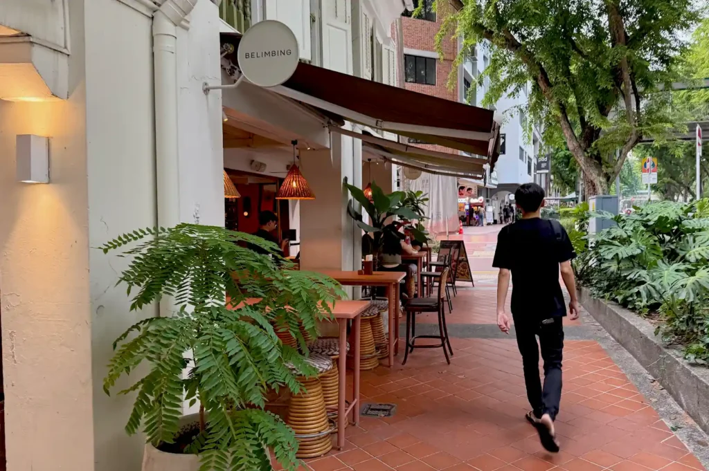 View of Belimbing restaurant’s storefront and outdoor walkway, highlighting the intersection of heritage architecture and modern dining in Singapore.