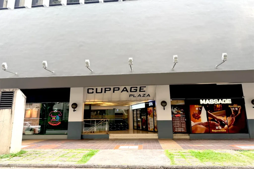 The exterior facade of Cuppage Plaza in Singapore, highlighting its main entrance, signage, and surrounding retail units.