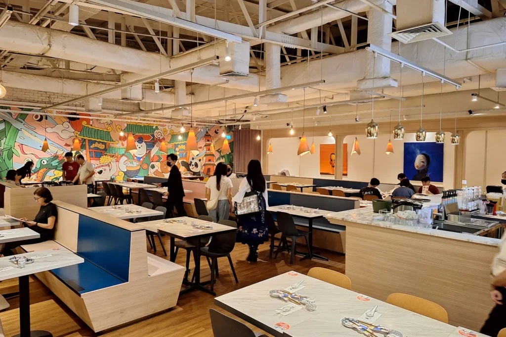 Spacious and modern dining area with colorful wall murals at the popular Omoté restaurant in Singapore.