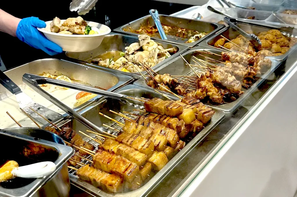 A variety of grilled meat skewers and prepared hot food choices available at Al Marche in Republic Plaza.