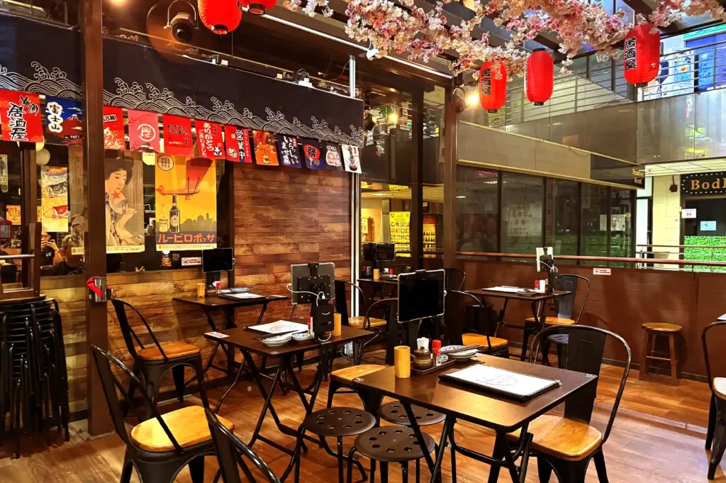 A Japanese restaurant interior adorned with red lanterns and cherry blossom decorations, capturing the cozy atmosphere where food conversations spark future dining adventures.