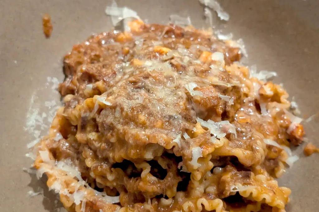 A warm bowl of handmade Italian pasta coated in rich meat ragu and freshly grated cheese at Fico Singapore.