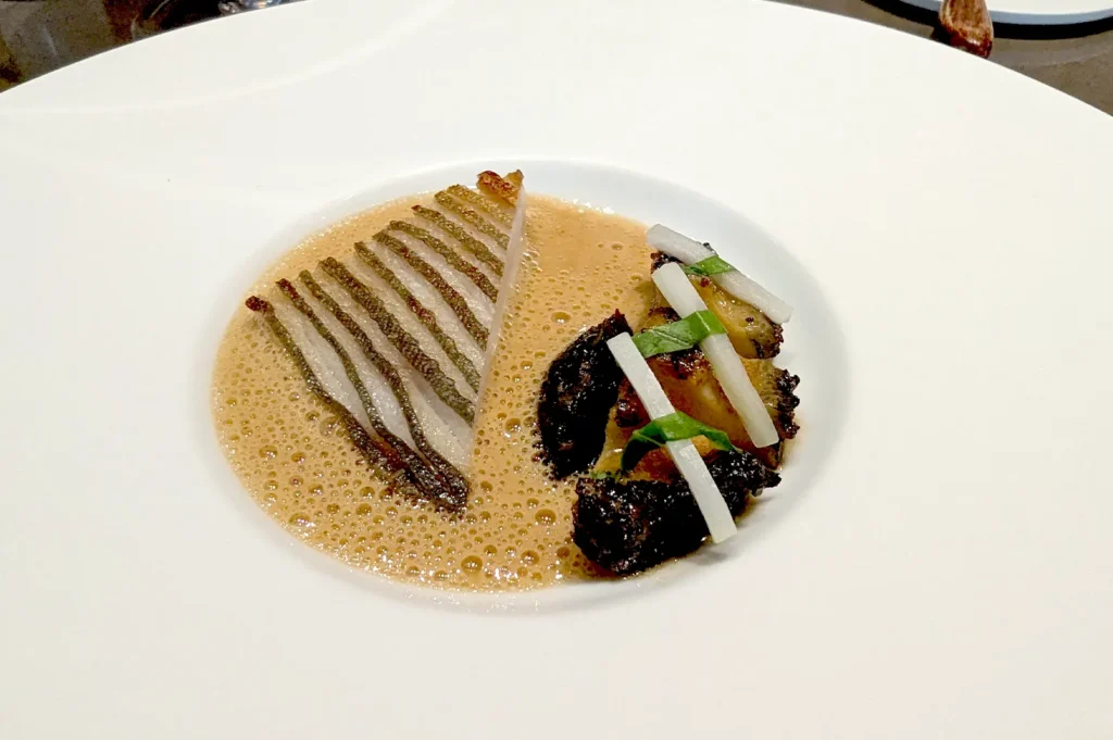 Silver pomfret and jade abalone served in a rich seafood broth at Seroja, showcasing two Michelin-star Malay Archipelago cuisine.
