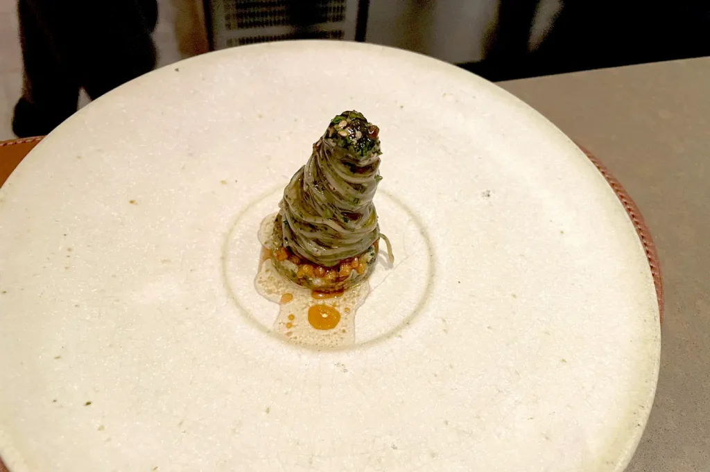 Betel leaf noodles with ulam dressing and mud crab delicately plated at Seroja in Singapore.