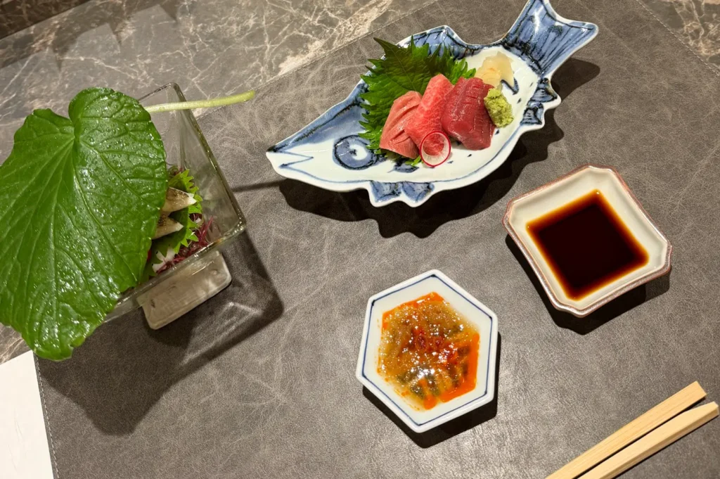Fine dining sashimi course featuring premium tuna served on a decorative fish-shaped plate at Jiin Omakase, Shaw Centre, Singapore.