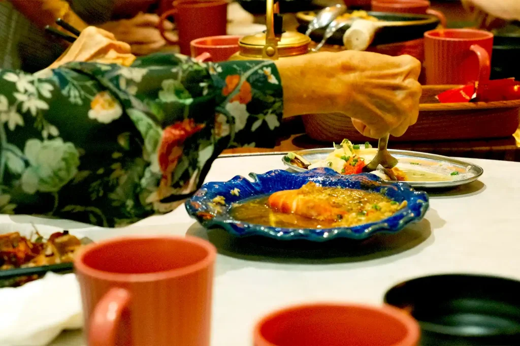 A close-up of a diner enjoying a seafood specialty served in a vibrant blue ceramic dish at Hup Lok.